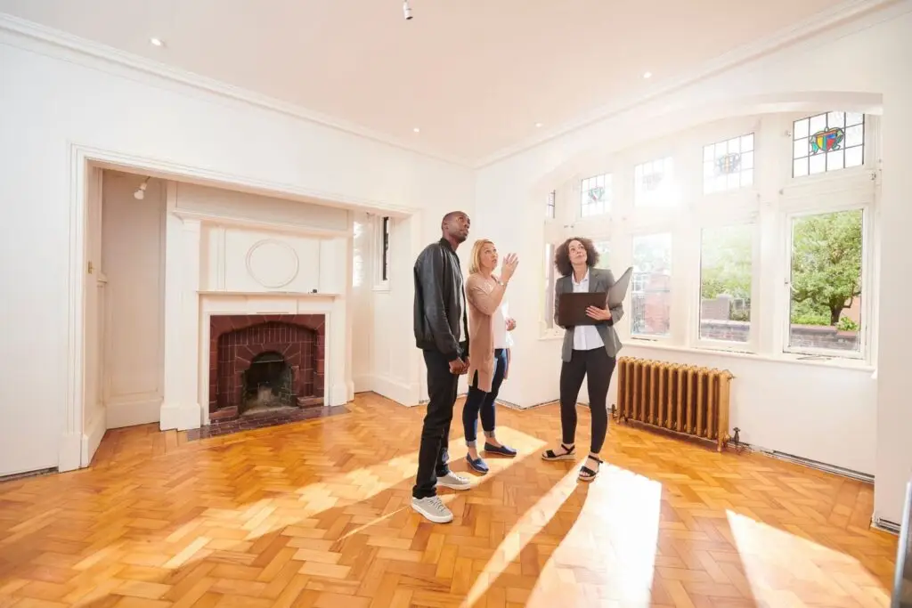 Real estate agent showing a young couple through an empty unit in a multi unit property
